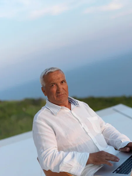 Senior man sitting outside — Stock Photo, Image