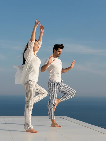 Jeune couple pratiquant le yoga — Photo