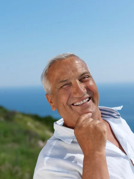 Senior man sitting outside — Stock Photo, Image