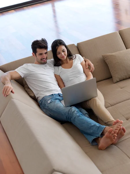Relajada pareja joven que trabaja en el ordenador portátil — Foto de Stock