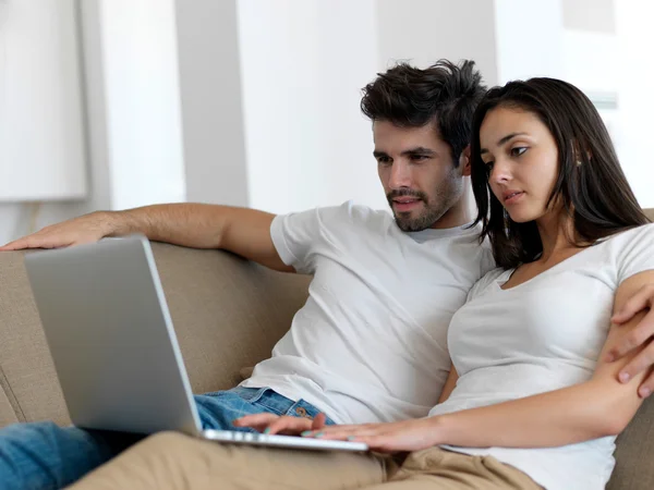 Relaxado jovem casal trabalhando no computador portátil — Fotografia de Stock