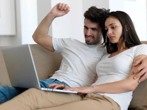 Relaxado jovem casal trabalhando no computador portátil — Fotografia de Stock