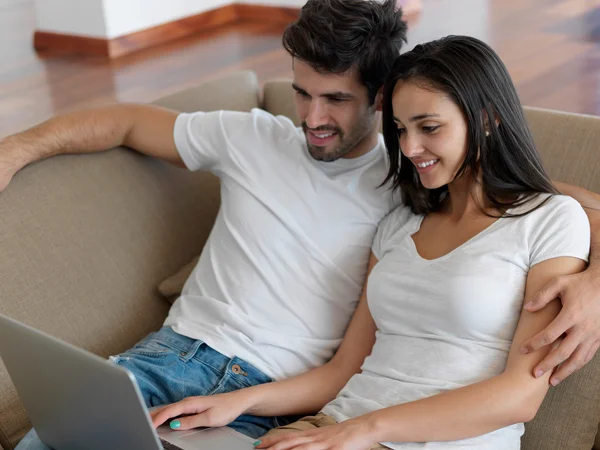 Relaxado jovem casal trabalhando no computador portátil — Fotografia de Stock