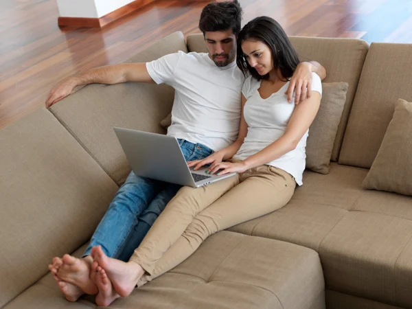 Relaxado jovem casal trabalhando no computador portátil — Fotografia de Stock