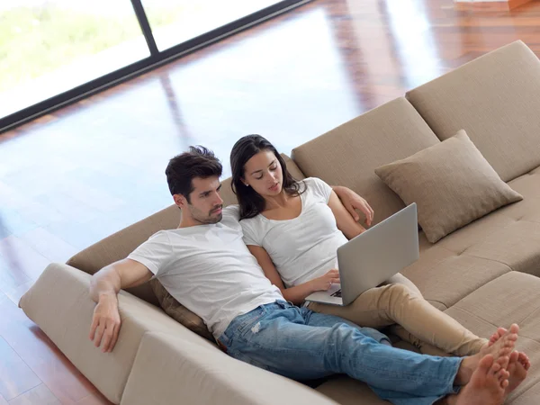 Relaxado jovem casal trabalhando no computador portátil — Fotografia de Stock