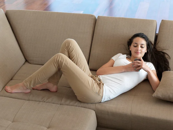 Femme sur canapé avec téléphone — Photo