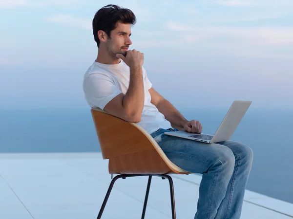 Relaxed young man at home on balcony — Stock Photo, Image