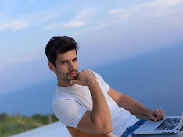 Relaxed young man at home on balcony — Stock Photo, Image