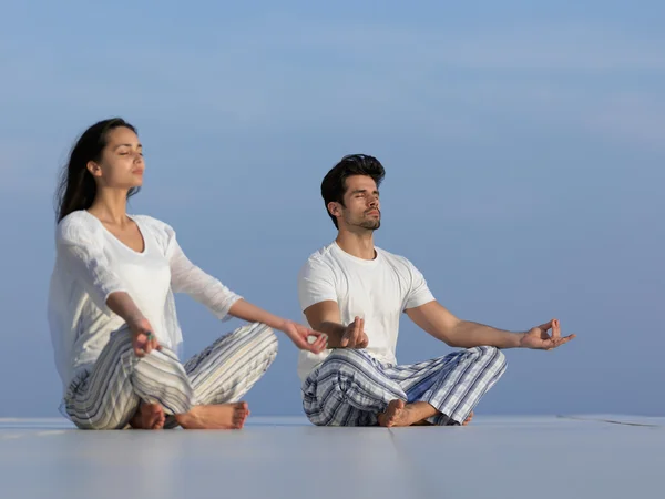 Jeune couple pratiquant le yoga — Photo