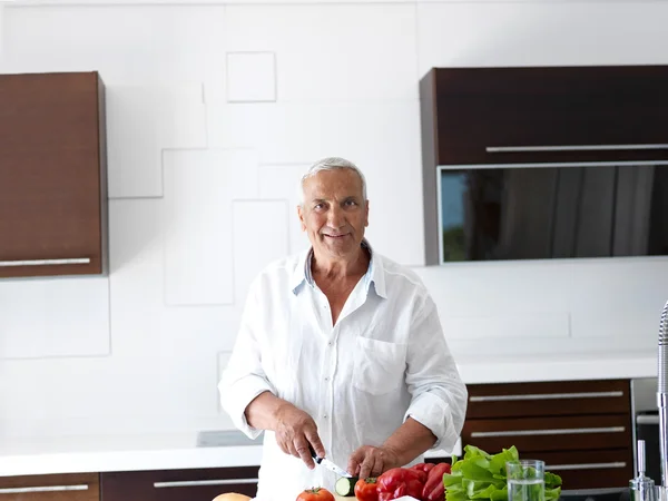 Man cooking at home preparing salad in kitchen — Stock Photo, Image