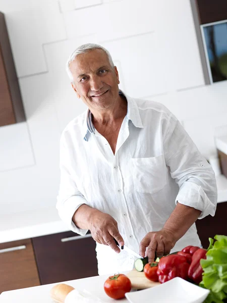 Hombre cocinando en casa preparando ensalada en la cocina —  Fotos de Stock