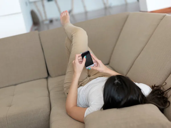 Femme sur canapé avec téléphone — Photo