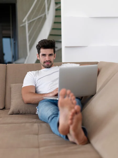 Giovane uomo a casa a lavorare sul computer portatile — Foto Stock