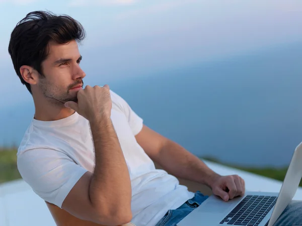 Relaxed young man at home on balcony — Stock Photo, Image