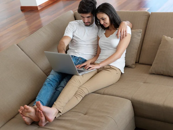 Relaxado jovem casal trabalhando no computador portátil — Fotografia de Stock