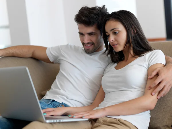 Relaxado jovem casal trabalhando no computador portátil — Fotografia de Stock