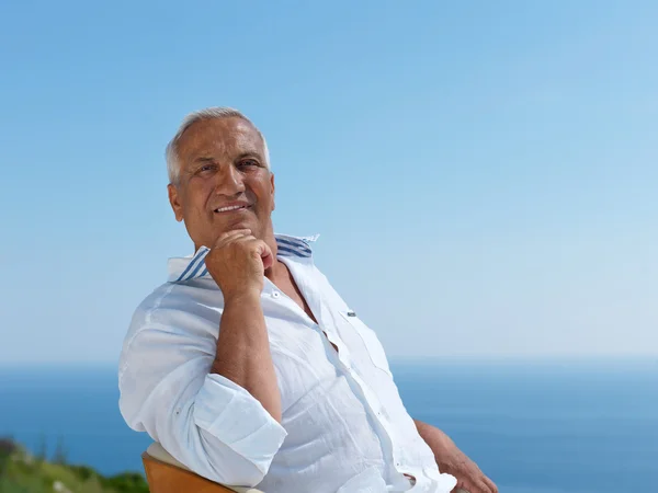 Senior man sitting outside — Stock Photo, Image