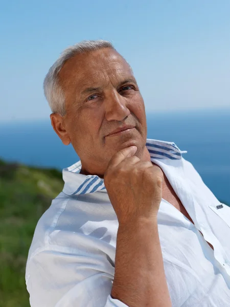 Senior man sitting outside — Stock Photo, Image