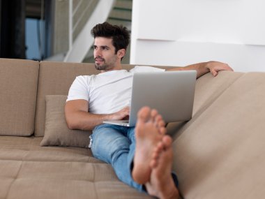 adam kanepede dizüstü bilgisayar ile rahatlatıcı