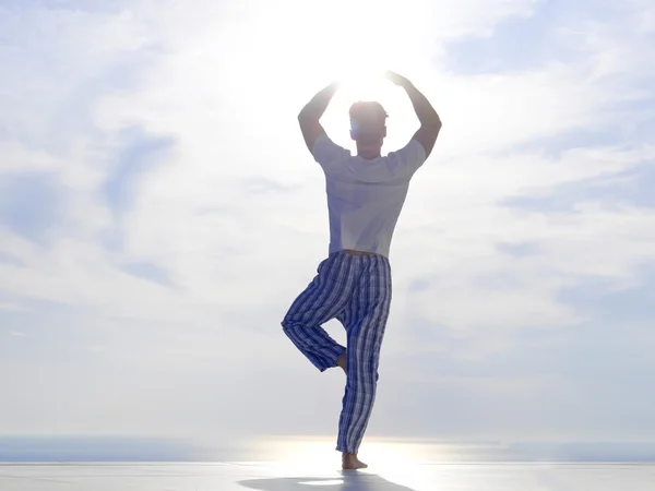 Junger Mann praktiziert Yoga — Stockfoto
