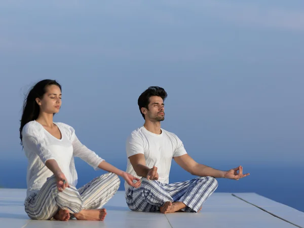 Jeune couple pratiquant le yoga — Photo