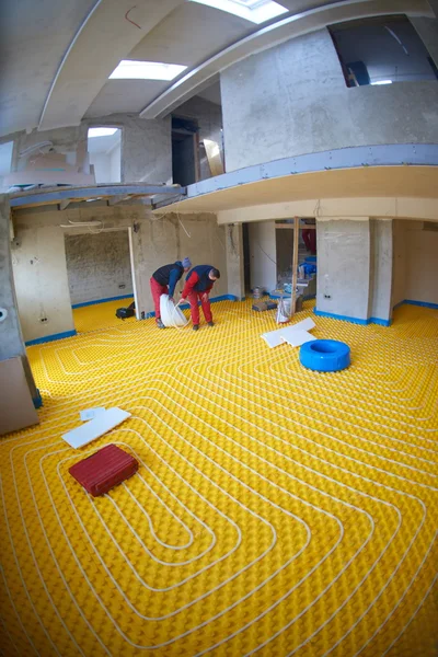 Workers installing underfloor heating system — Stock Photo, Image