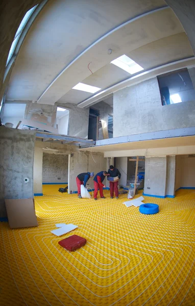Робітники встановлюють систему теплої підлоги — стокове фото