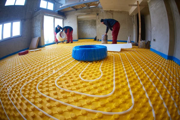 Workers installing underfloor heating system — Stock Photo, Image