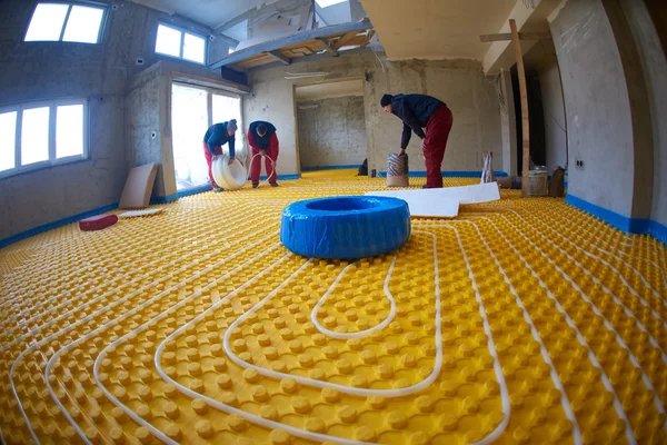 Workers installing underfloor heating system — Stock Photo, Image