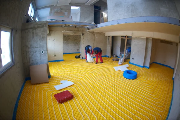 Workers installing underfloor heating system — Stock Photo, Image