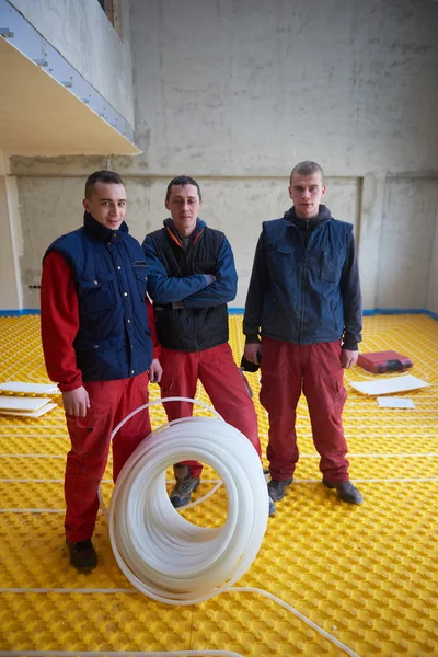 Workers installing underfloor heating system — Stock Photo, Image