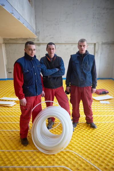 Workers installing underfloor heating system — Stock Photo, Image