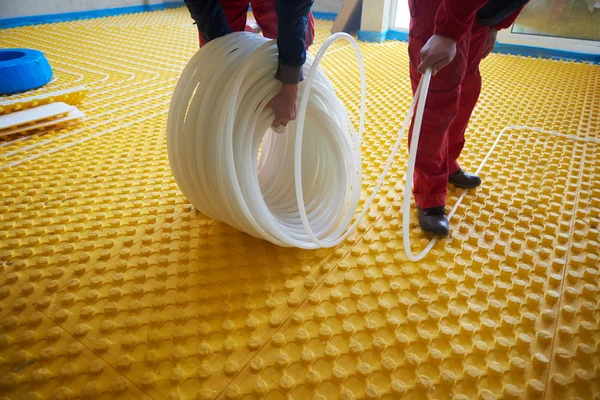 Arbetstagare att installera golvvärmesystem — Stockfoto