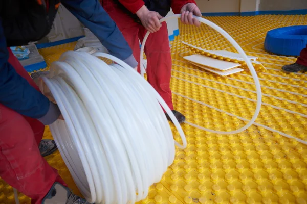 Workers installing underfloor heating system — Stock Photo, Image