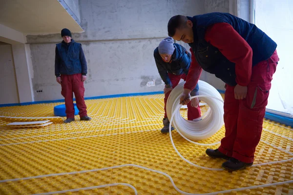 Lavoratori che installano sistema di riscaldamento a pavimento — Foto Stock