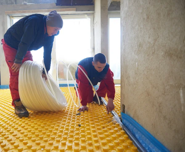Dělníci instalovat systém podlahového vytápění — Stock fotografie