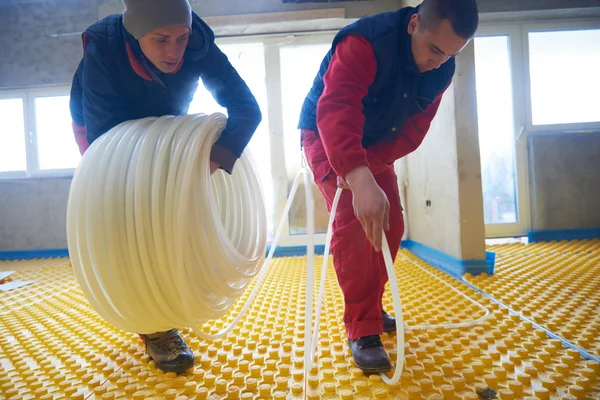 Workers installing underfloor heating system — Stock Photo, Image