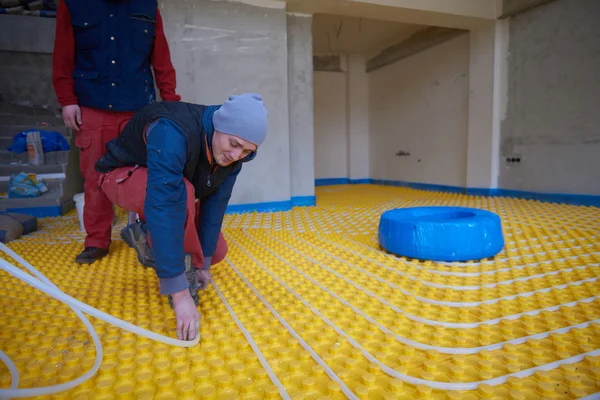 Workers installing underfloor heating system — Stock Photo, Image