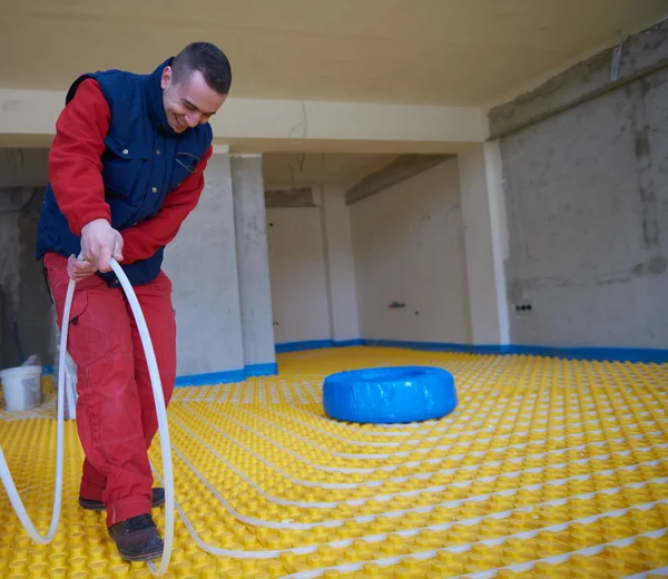 Trabalhador instalação de piso radiante sistema de aquecimento — Fotografia de Stock