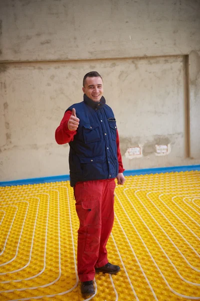 Trabalhador instalação de piso radiante sistema de aquecimento — Fotografia de Stock