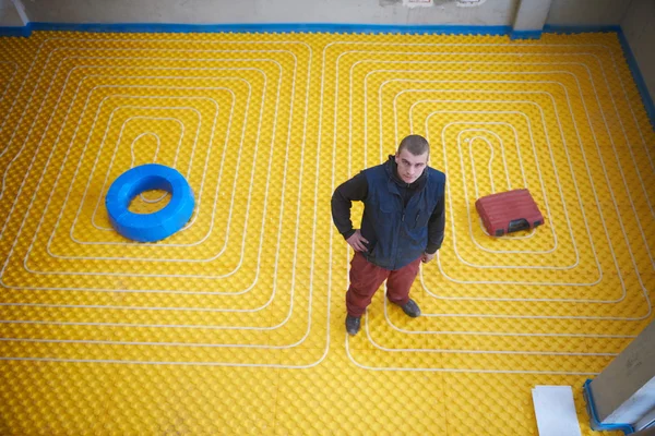 Trabajador instalación de sistema de calefacción por suelo radiante —  Fotos de Stock