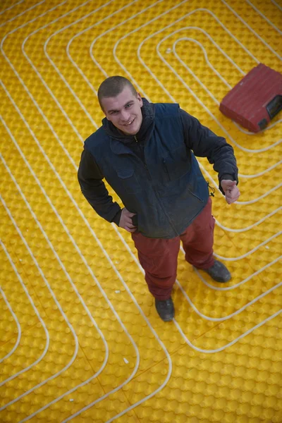 Trabalhador instalação de piso radiante sistema de aquecimento — Fotografia de Stock