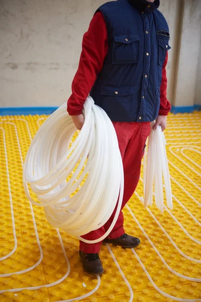 Worker installing underfloor heating system — Stock Photo, Image