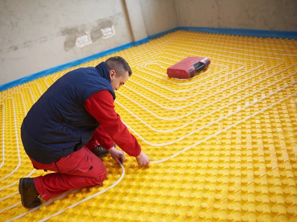 Trabalhador instalação de piso radiante sistema de aquecimento — Fotografia de Stock