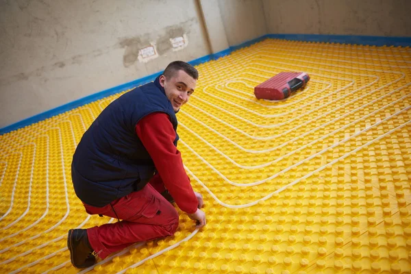 Trabajador instalación de sistema de calefacción por suelo radiante — Foto de Stock