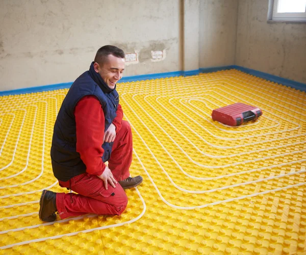 Trabalhador instalação de piso radiante sistema de aquecimento — Fotografia de Stock