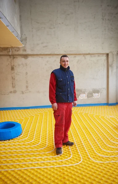 Dělník, instalace podlahového vytápění — Stock fotografie