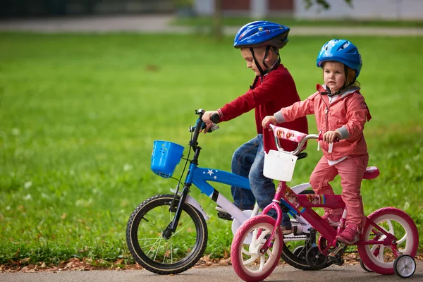 Menino e menina com bicicleta — Fotografia de Stock