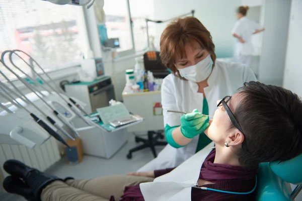 去看牙医与背景中的女医生正在检查女病人的特写 — 图库照片