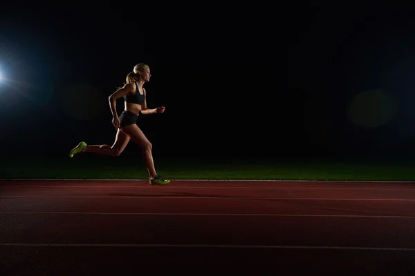 Mujer atlética corriendo en pista — Foto de Stock